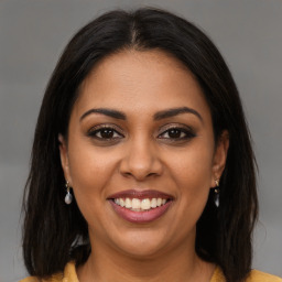 Joyful latino young-adult female with medium  brown hair and brown eyes