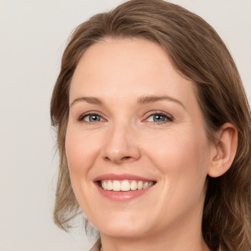 Joyful white young-adult female with medium  brown hair and blue eyes