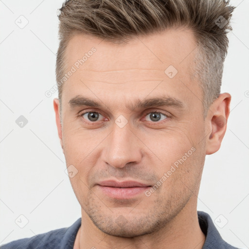 Joyful white adult male with short  brown hair and brown eyes