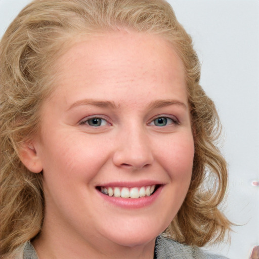 Joyful white young-adult female with medium  brown hair and blue eyes