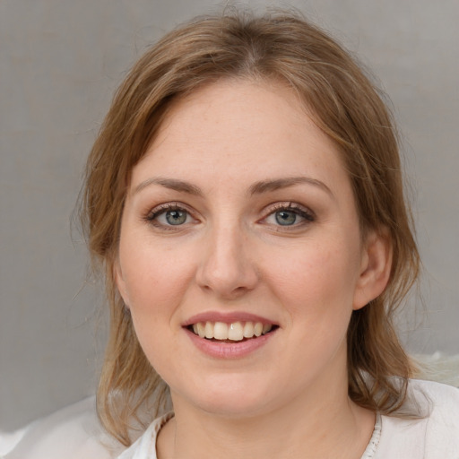 Joyful white young-adult female with medium  brown hair and blue eyes