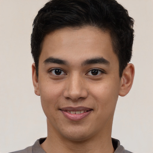 Joyful latino young-adult male with short  brown hair and brown eyes