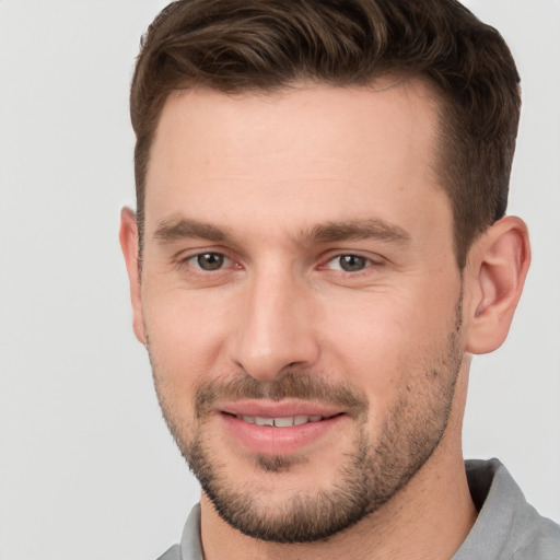 Joyful white young-adult male with short  brown hair and brown eyes