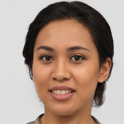 Joyful latino young-adult female with medium  brown hair and brown eyes