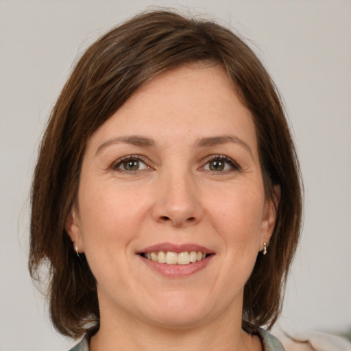 Joyful white young-adult female with medium  brown hair and grey eyes