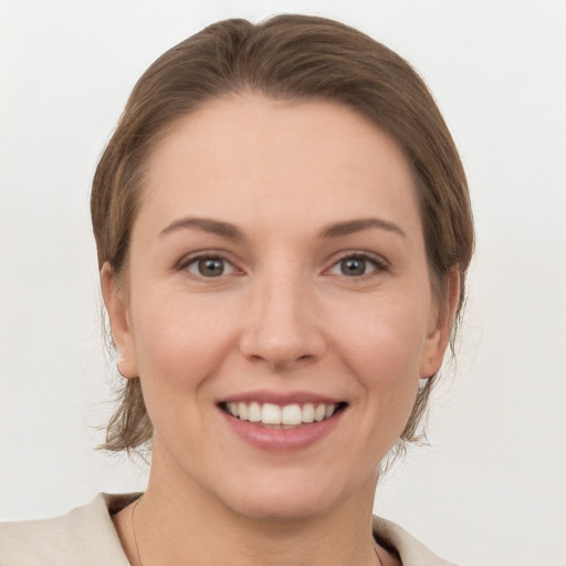 Joyful white young-adult female with medium  brown hair and grey eyes