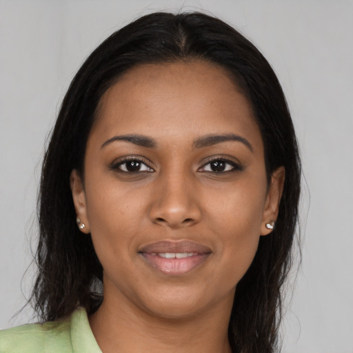 Joyful black young-adult female with long  black hair and brown eyes