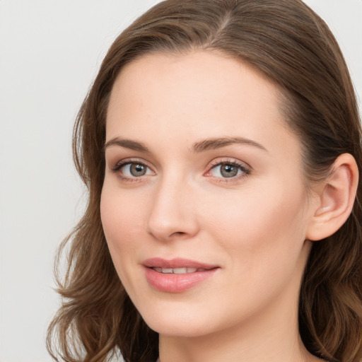 Joyful white young-adult female with long  brown hair and blue eyes