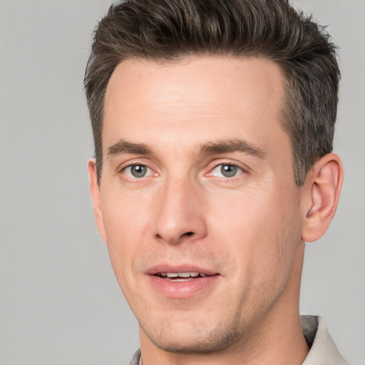 Joyful white adult male with short  brown hair and grey eyes