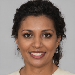 Joyful black adult female with medium  brown hair and brown eyes