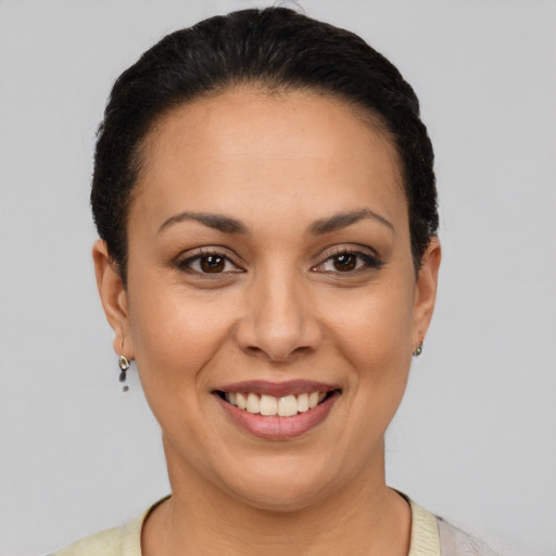 Joyful latino young-adult female with short  black hair and brown eyes
