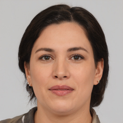 Joyful white adult female with medium  brown hair and brown eyes