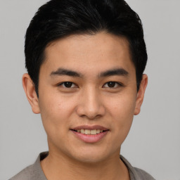 Joyful asian young-adult male with short  black hair and brown eyes