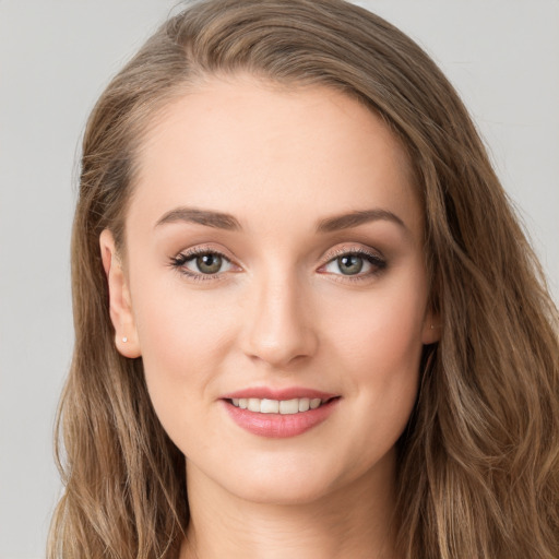 Joyful white young-adult female with long  brown hair and green eyes