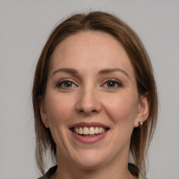 Joyful white young-adult female with medium  brown hair and grey eyes