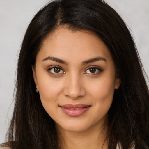 Joyful latino young-adult female with long  brown hair and brown eyes