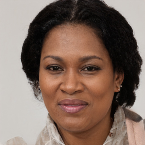 Joyful black adult female with medium  brown hair and brown eyes