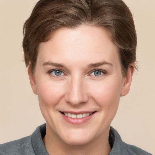 Joyful white young-adult female with short  brown hair and grey eyes