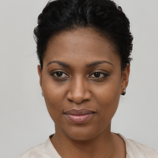 Joyful black young-adult female with short  black hair and brown eyes