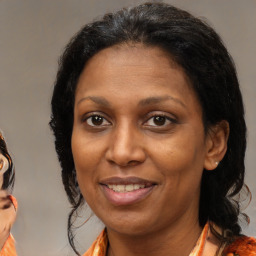 Joyful black adult female with medium  brown hair and brown eyes