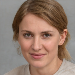 Joyful white young-adult female with medium  brown hair and blue eyes