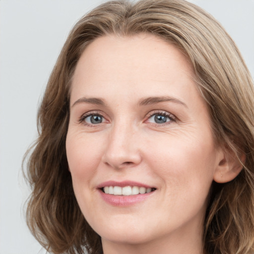 Joyful white young-adult female with long  brown hair and blue eyes