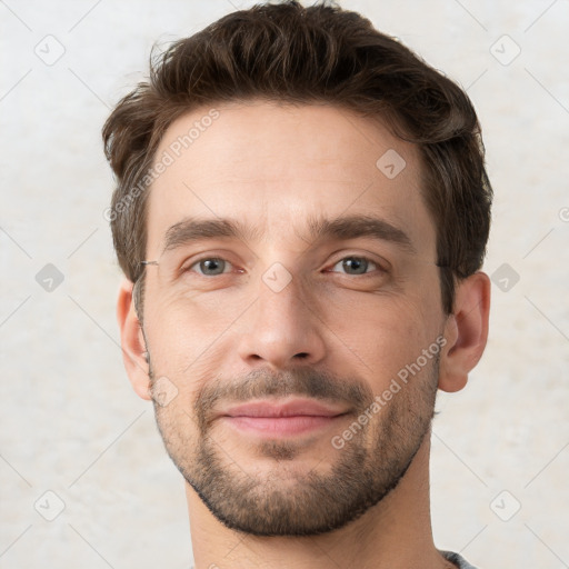 Joyful white young-adult male with short  brown hair and grey eyes