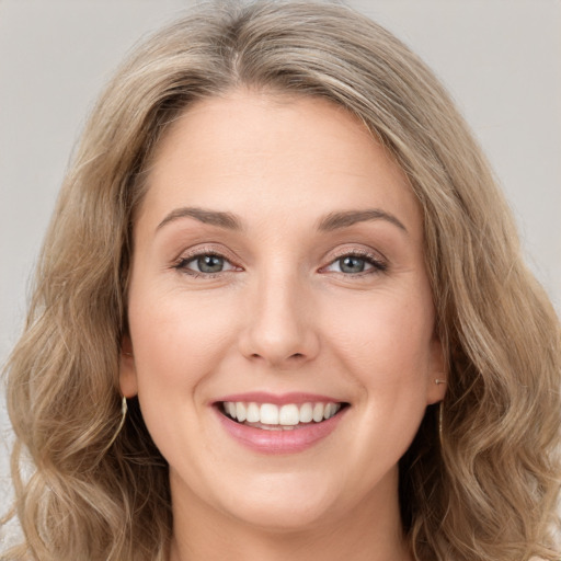 Joyful white young-adult female with long  brown hair and green eyes