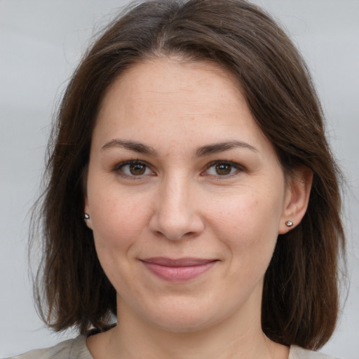 Joyful white adult female with medium  brown hair and grey eyes