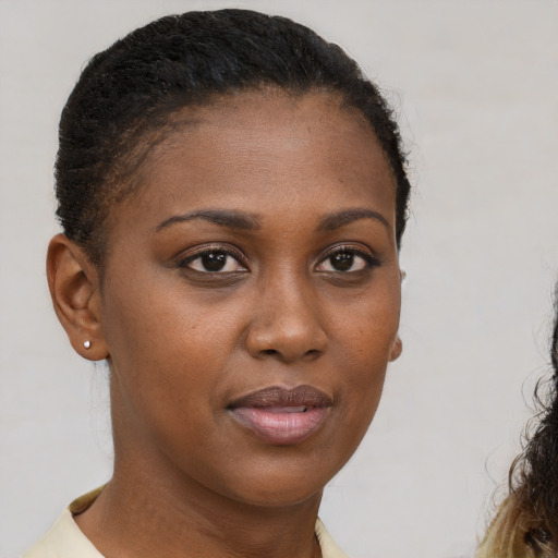 Joyful black young-adult female with short  brown hair and brown eyes