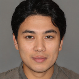 Joyful latino young-adult male with short  brown hair and brown eyes