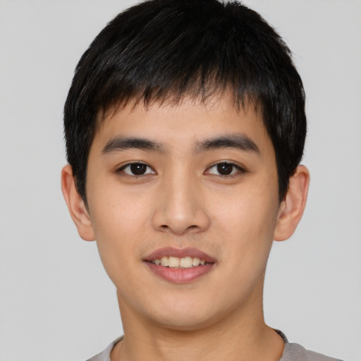 Joyful asian young-adult male with short  black hair and brown eyes