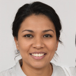 Joyful latino young-adult female with medium  brown hair and brown eyes