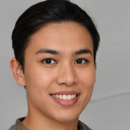 Joyful asian young-adult male with short  brown hair and brown eyes