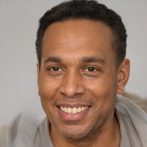 Joyful latino adult male with short  brown hair and brown eyes