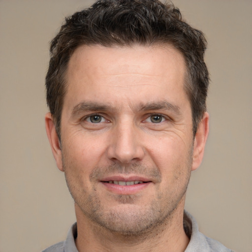 Joyful white adult male with short  brown hair and brown eyes