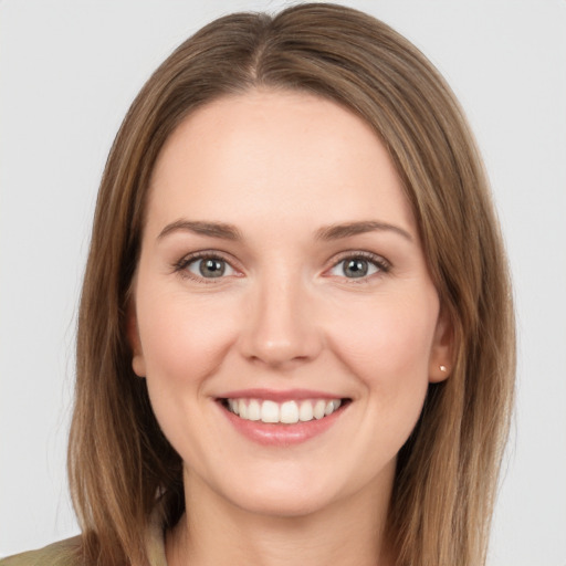 Joyful white young-adult female with long  brown hair and grey eyes