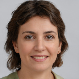 Joyful white young-adult female with medium  brown hair and green eyes