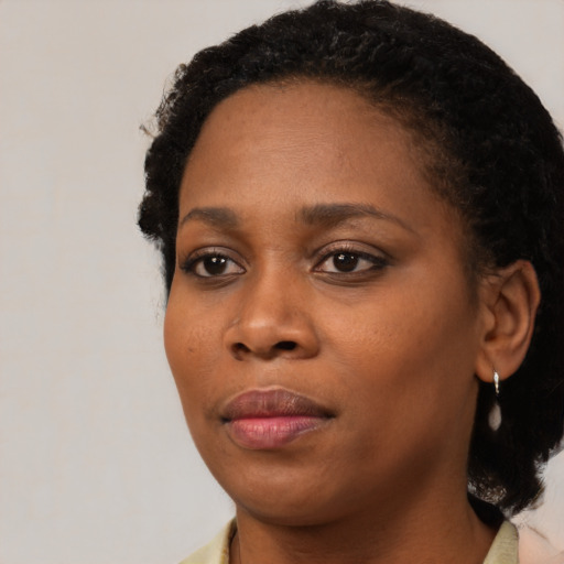 Joyful black young-adult female with medium  black hair and brown eyes