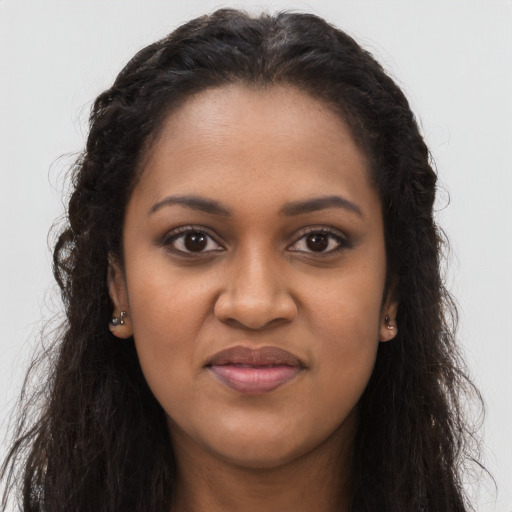 Joyful black young-adult female with long  brown hair and brown eyes