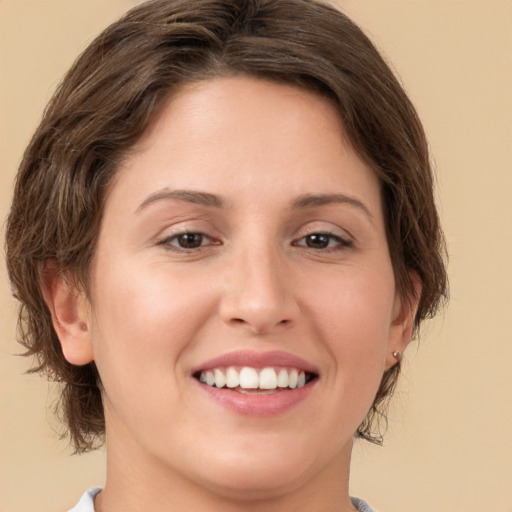 Joyful white young-adult female with medium  brown hair and green eyes