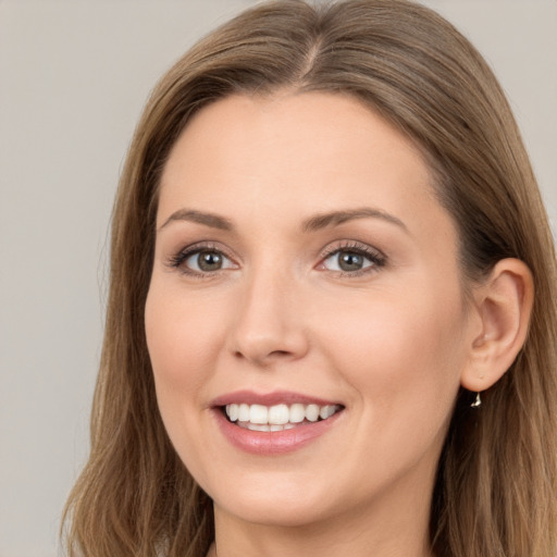 Joyful white young-adult female with long  brown hair and brown eyes