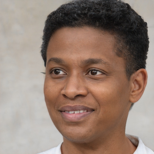 Joyful black young-adult male with short  black hair and brown eyes