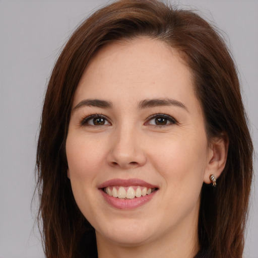 Joyful white young-adult female with long  brown hair and brown eyes