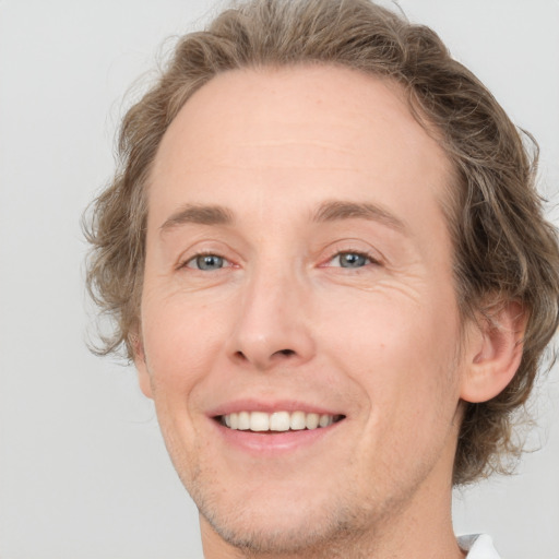 Joyful white adult male with medium  brown hair and grey eyes