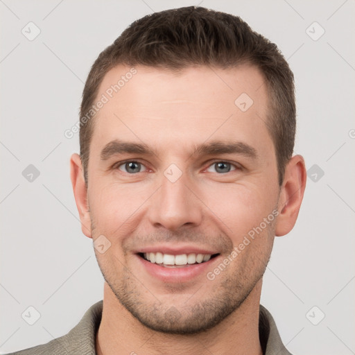 Joyful white young-adult male with short  brown hair and grey eyes