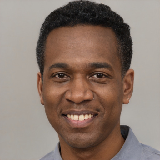 Joyful latino adult male with short  black hair and brown eyes