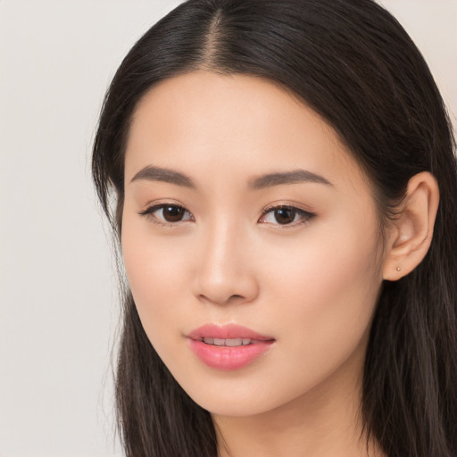 Joyful asian young-adult female with long  brown hair and brown eyes