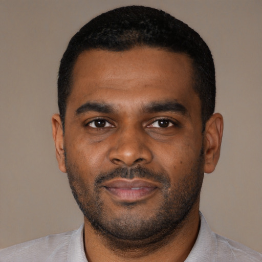 Joyful black young-adult male with short  black hair and brown eyes