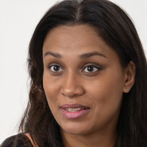 Joyful black young-adult female with long  brown hair and brown eyes